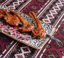 Spicy grilled lamb chops on ornate plate photo