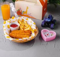 Kids meal with toy and juice on table photo