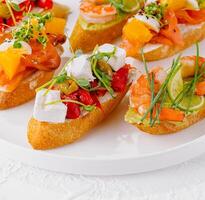 Elegant platter of assorted bruschetta with fresh toppings on a white background photo