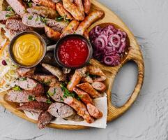Assorted grilled sausages platter with dips photo