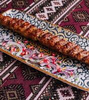 Traditional grilled kebab on ornate plate photo