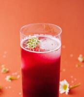 Refreshing berry smoothie with floral garnish photo