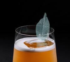 Elegant cocktail with a decorative leaf garnish photo