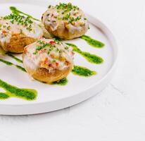 Gourmet stuffed mushrooms on plate with pesto drizzle photo