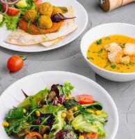 Fresh vegetarian salad and soup meal setup photo