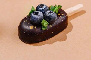 Gourmet ice cream popsicles with berries and chocolate glaze photo