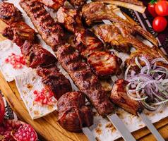 Traditional grilled shashlik skewers on wooden board photo