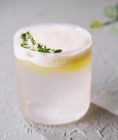 Refreshing lemon cocktail with thyme garnish photo