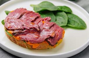 Gourmet beef tenderloin on toast with spinach photo