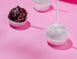 Gourmet chocolate cake pops on pink background photo