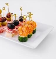 Gourmet appetizer selection on a white platter against a clean backdrop photo