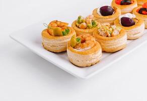 Gourmet assorted mini tartlets on white plate photo