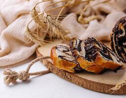 Rustic poppy seed swirl bread on wooden serving board photo