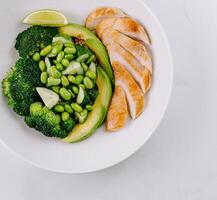 Healthy grilled chicken plate with vegetables and lime photo