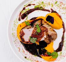 Gourmet pork tenderloin with colorful puree photo