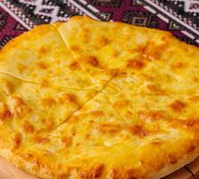 Traditional georgian cheese bread khachapuri on wooden board photo