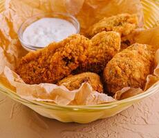 Crisp crunchy golden chicken legs and wings deep fried photo