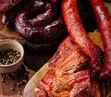 Assortment of smoked meats on wooden board photo