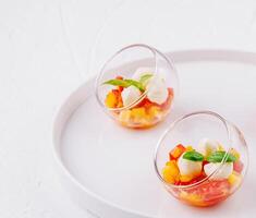 Elegant fruit salad in glass bowls photo