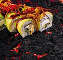 Spicy avocado sushi roll on lava-inspired surface photo