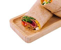 Fresh chicken wrap sandwich on wooden board photo