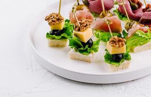 Gourmet canapes platter on white background photo