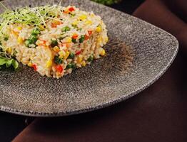 Bowl of rice with peas, corn and red peppers photo