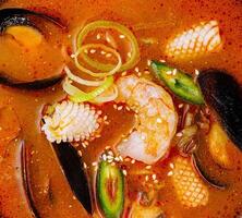 Spicy seafood soup close up background photo