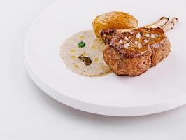 Gourmet lamb chop on elegant white plate photo