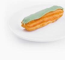 Fresh pistachio eclair on white plate photo