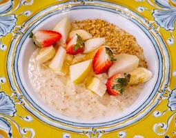 vistoso cuenco de harina de avena con Fresco frutas foto