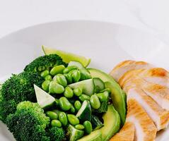 Healthy grilled chicken and green vegetables plate photo