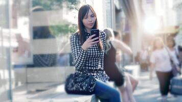 ciudad estilo de vida retrato de atractivo confidente mujer mirando en inteligente teléfono video