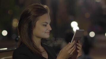 jung Frau mit Tablette Computer im das Park beim Nacht video