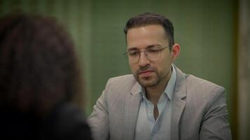 Man in formal wear with glasses and beard converses with woman at event video