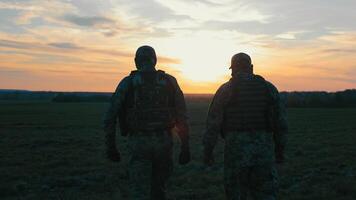 Soldiers Observing Sunset in the Field, Silhouettes of two soldiers watching the sunset over a field. video