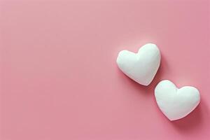 Two Heart Shaped Marshmallows on Pink Background photo