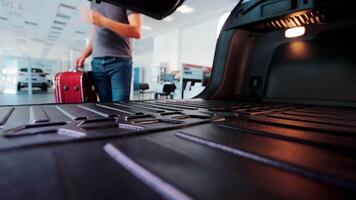 Travel by car. A tourist puts a suitcase in the trunk of a car, view from the trunk. video