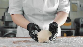 le cuisinier mélanges le pâte avec le sien mains et prépare le forme pour cuisson pain. fait maison pâte préparation. video