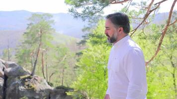 Tourist holiday hike to the top. . A man in white clothes climbs up. Tourist walk video