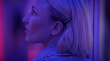 ung blond kvinna utforska rum av speglar i drömlik fantasi neon ljus video