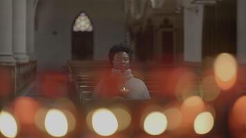 Jeune africain femme avec frisé cheveux prier à l'intérieur église video