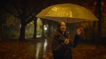 feliz despreocupado mulher dançando com guarda-chuva lado de fora dentro chuvoso noite video