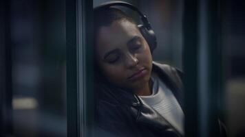 stedelijk levensstijl portret van ontspannen vrouw persoon met oortelefoons spelen geluid video