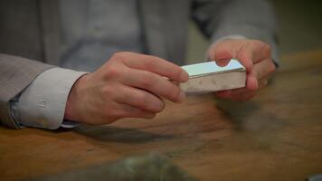 A man in a suit makes a gesture holding a silver bar in his hands video