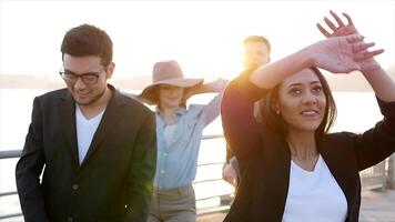 diverso grupo de joven personas bailando juntos fuera de a puesta de sol video