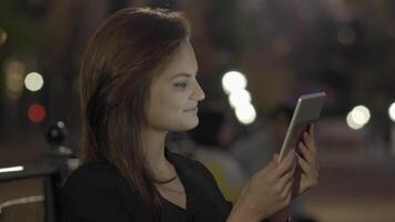 jung Frau mit Tablette Computer im das Park beim Nacht video