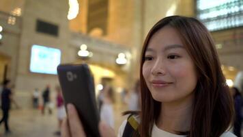 joven asiático mujer utilizando inteligente teléfono dispositivo en el ciudad calles video