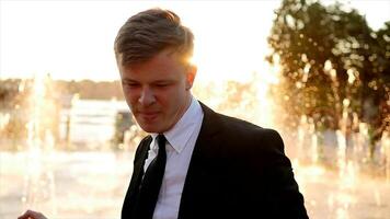 Young Happy Businessman Dancing Cheerful in Water Fountain at Sunset video