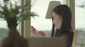 joven asiático mujer utilizando ordenador portátil computadora dentro Departamento hogar video